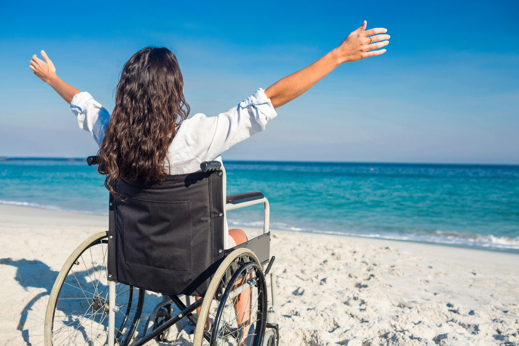 Disabled woman with arms outstretched at the beach